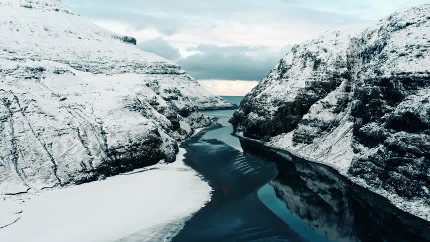 A river that passes between two mountains that are covered in snow