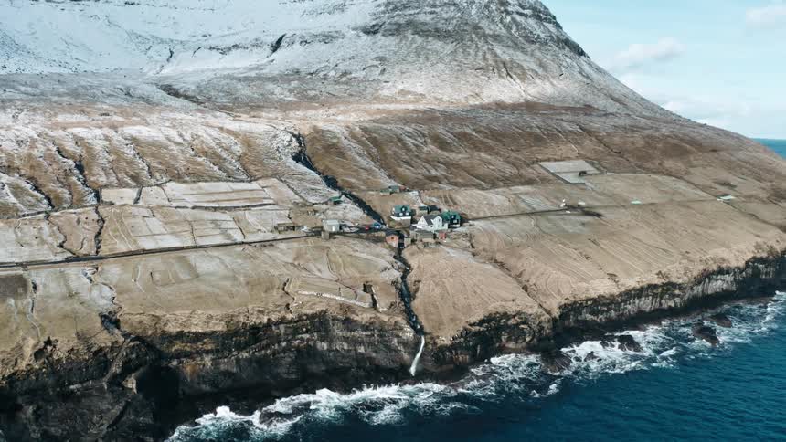 A small village of houses on a mountain facing the ocean