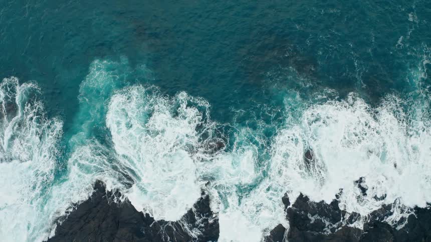Sea with choppy waves breaking on the mountain coast