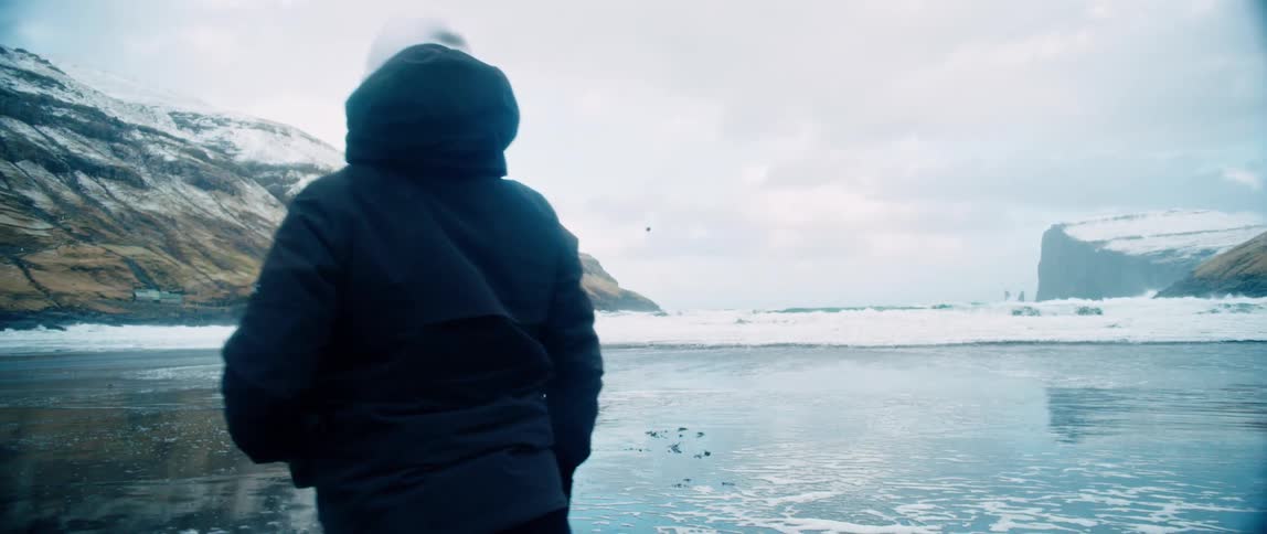 A person plays a ball on the beach during winter