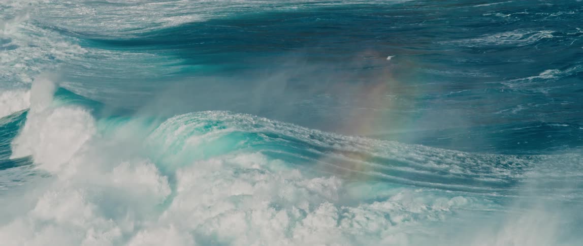Waves travel to the shore and forms a rainbow
