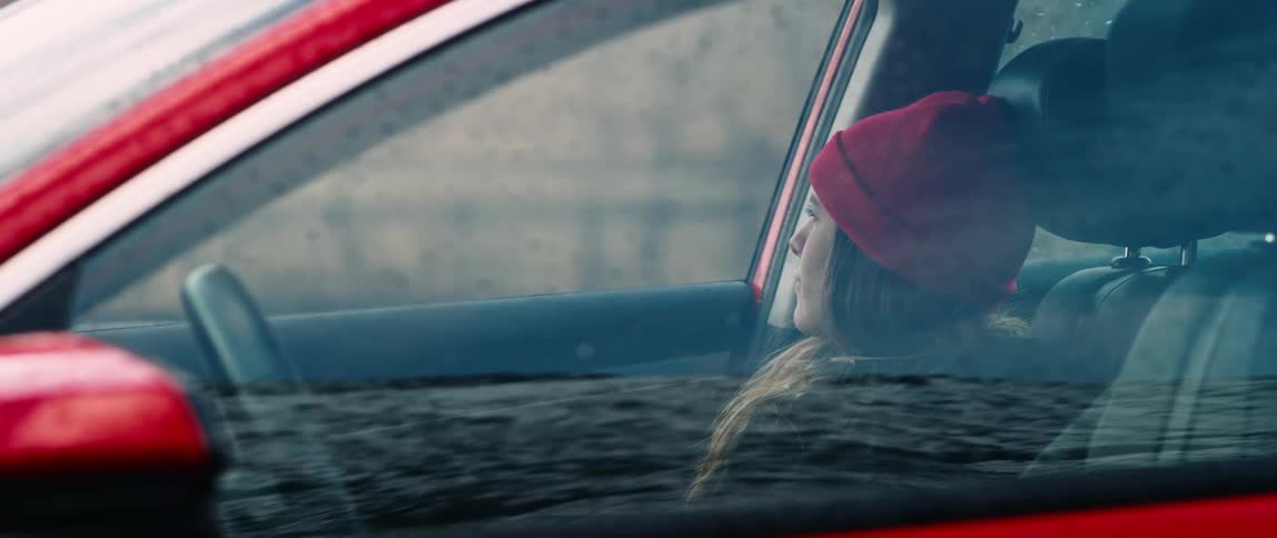 A young woman thoughtful in the parked car