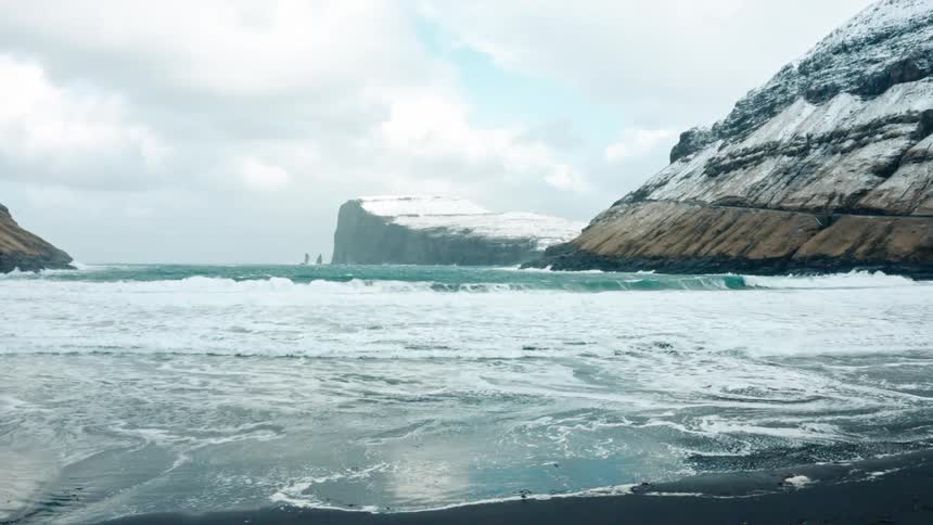 Arctic sea rolling onto a beach near a glacier