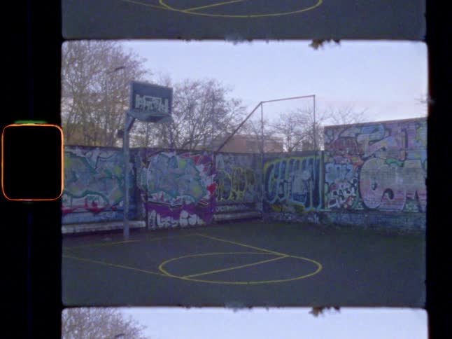A basketball court with walls covered in graffiti