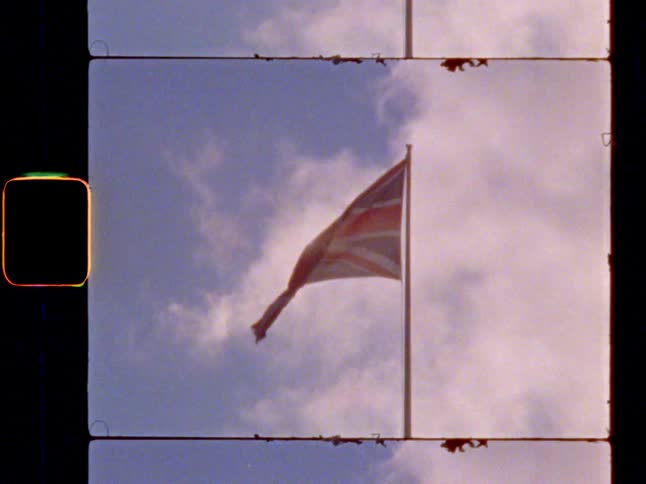 British flag waves in the wind under cloudy sky