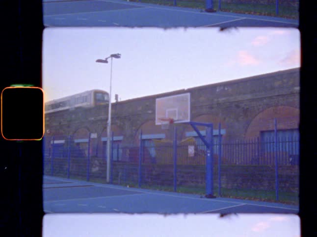 A train passes by an outdoor basketball court