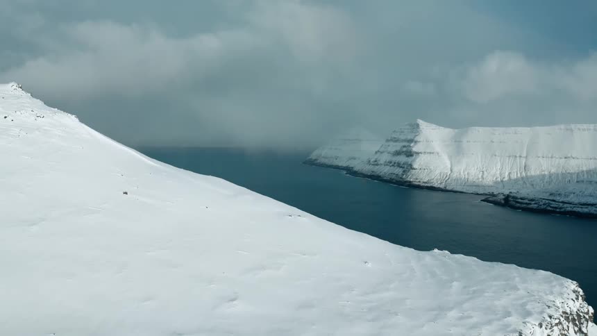 An aerial view of the arctic with mountains around it