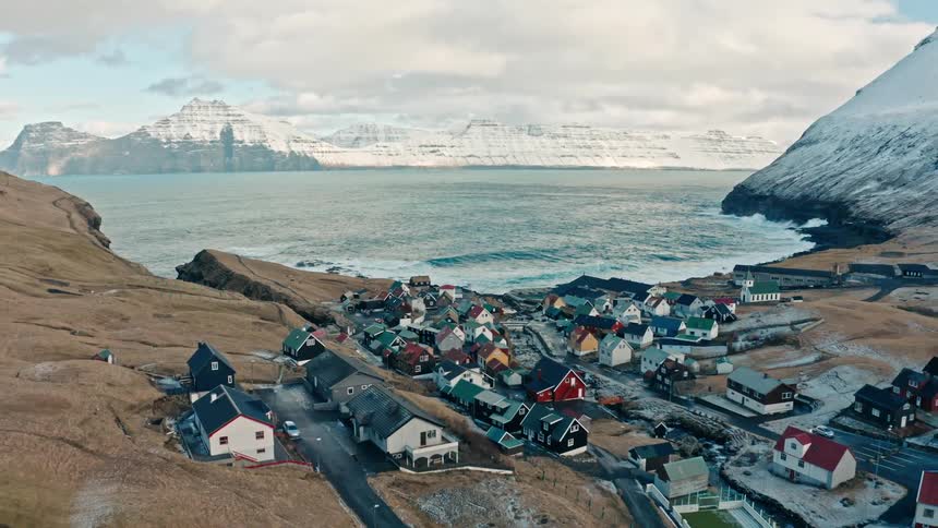 Skyline of a small coastal town between icy mountains