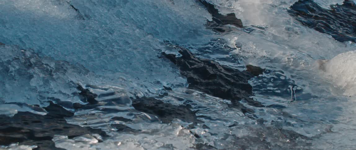 A stream of water is flowing beneath a layer of ice