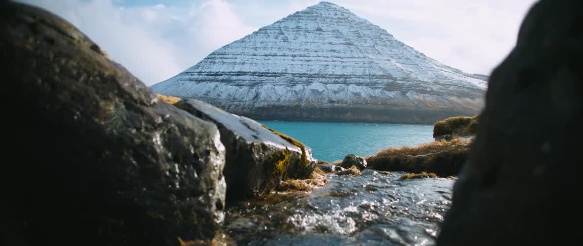The water pours over the rocks by the mountain