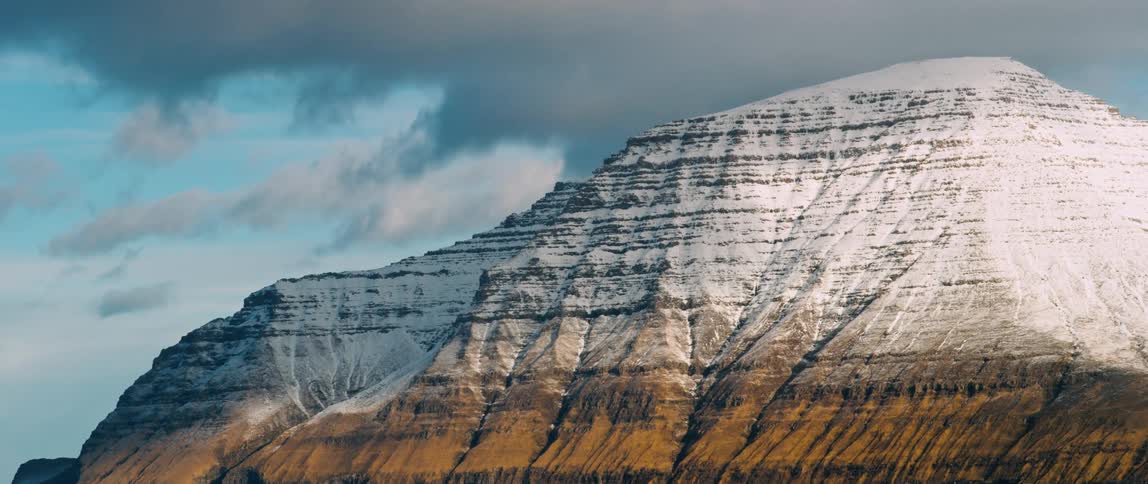 Majestic mountain covered in snow next to the ocean