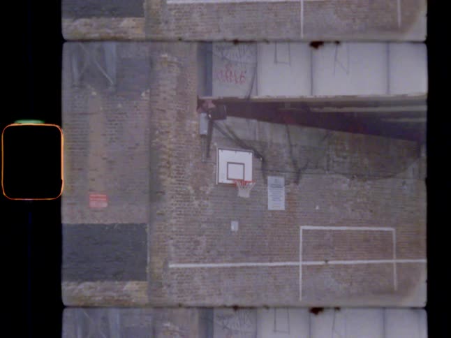 A basketball hoop on a wall under a bridge
