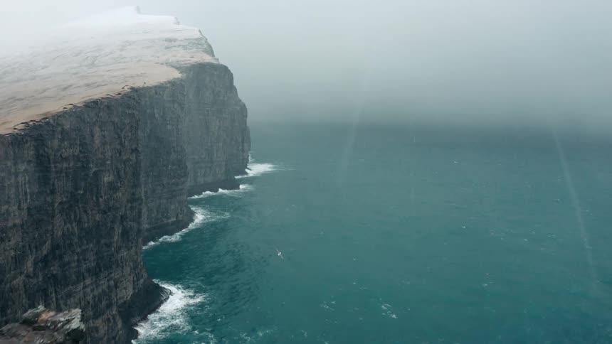 Aerial view of coastal cliffs under a snow storm