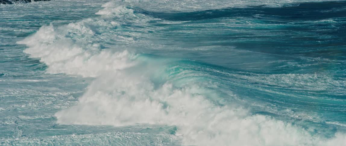 Waves curl and splash as they roll into shore