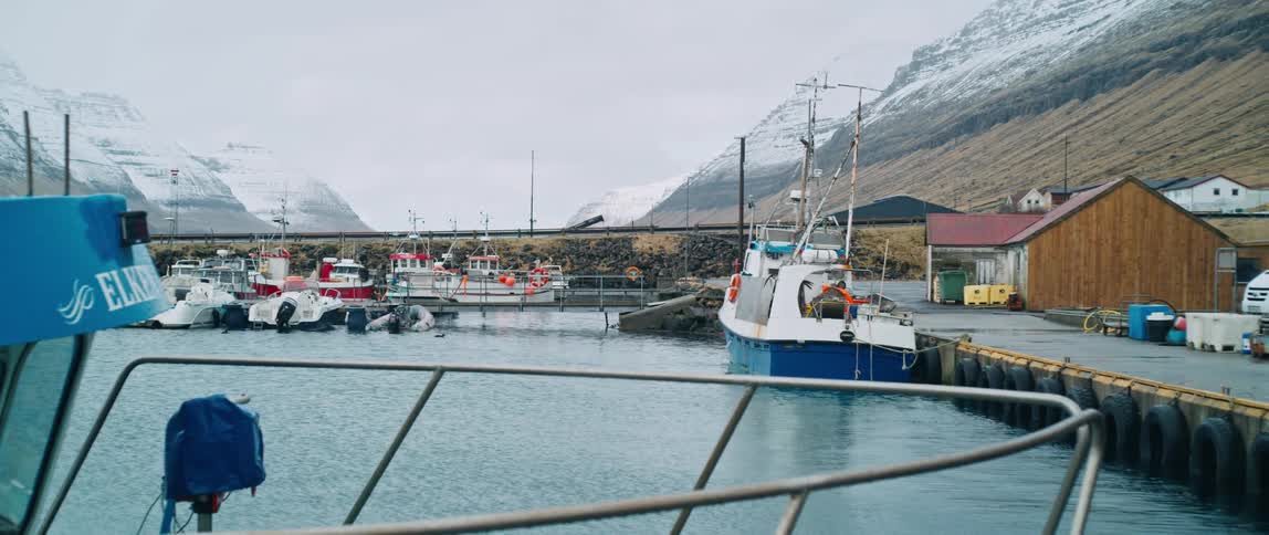 Two boats docked in small town in Faroe Islands