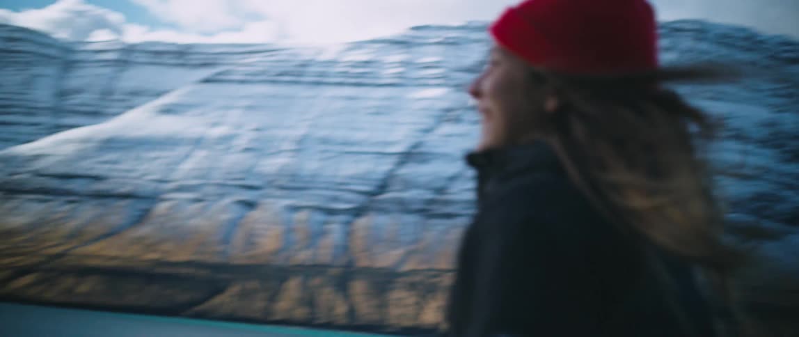 Happy woman runs to her car in the mountains