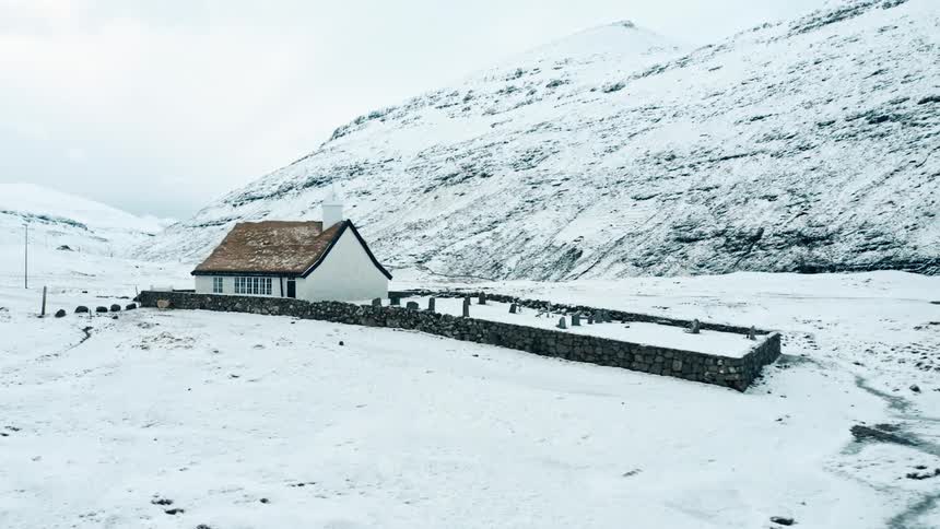 Panorama of a church with a cemetery amidst a snowcovered mountain