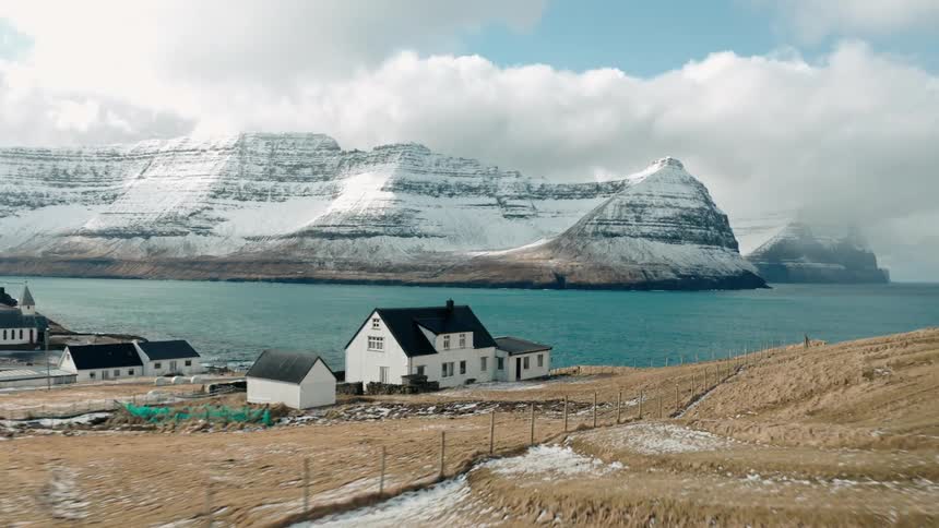 Aerial view of a small coastal town next to snowy mountains