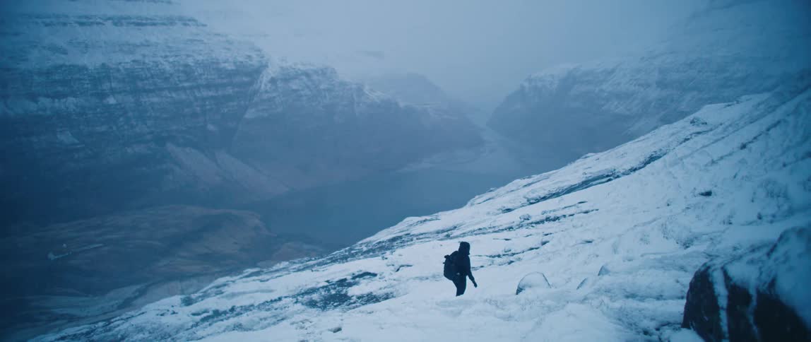 A person is hiking on the snow covered mountains