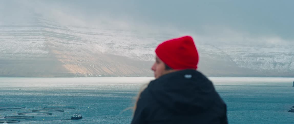 A woman looks over the mountains in the Faroe Islands
