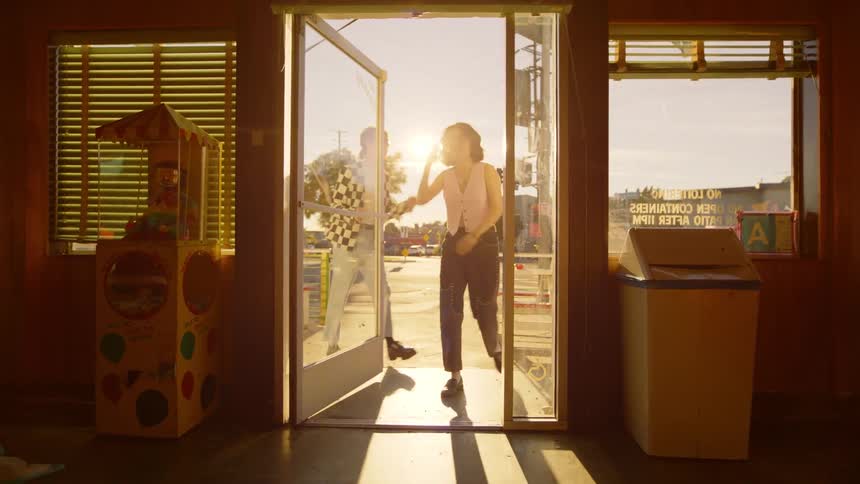 One person opens the door and holds it for the other person and they both enter