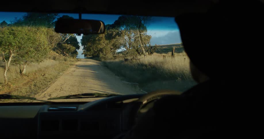 A person is driving on a dirt road