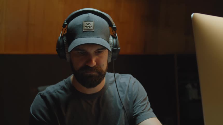 A man in a studio composing a song on the piano