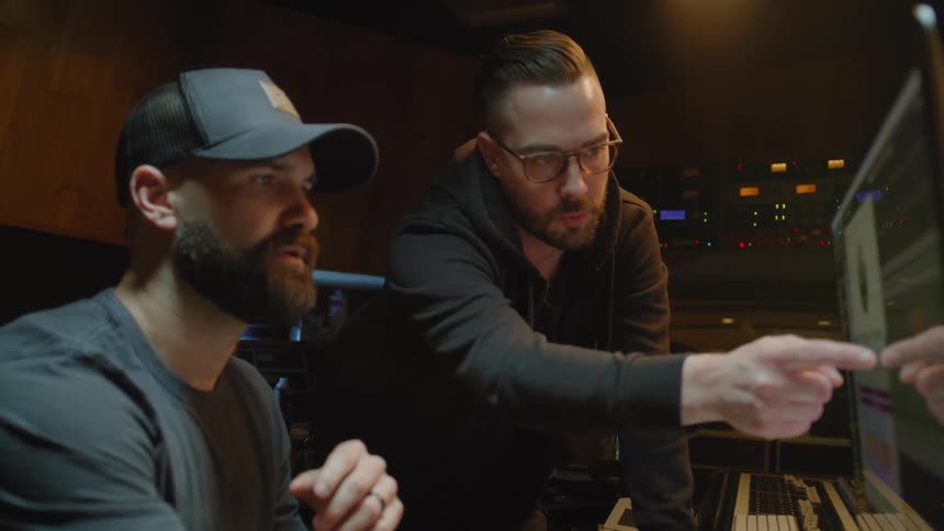 Men in a music studio create music on the computer