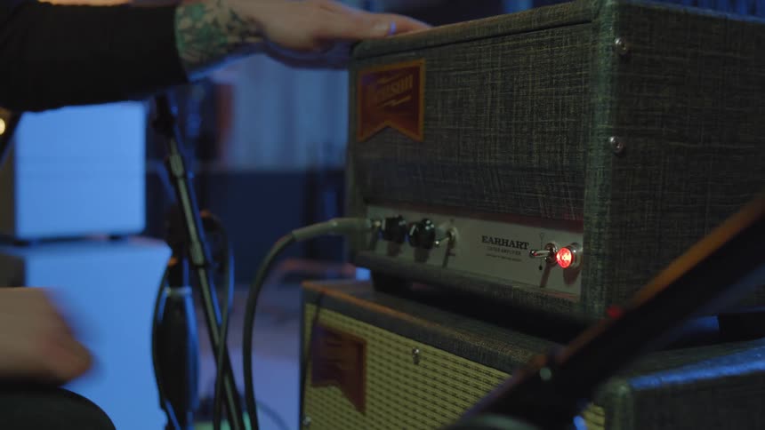 A person connecting cables to a speaker