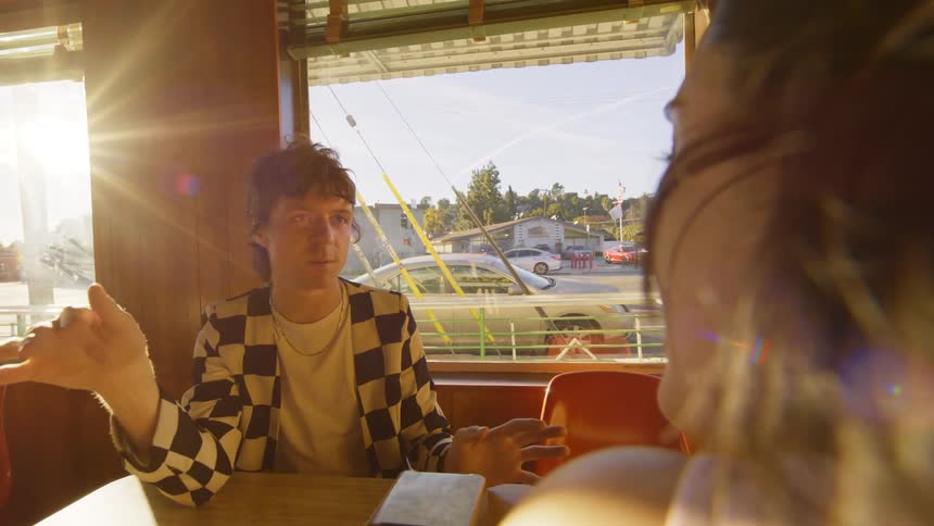 A teenage couple talking in a caf