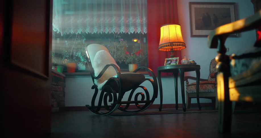 The rocking chair is moving in the empty room