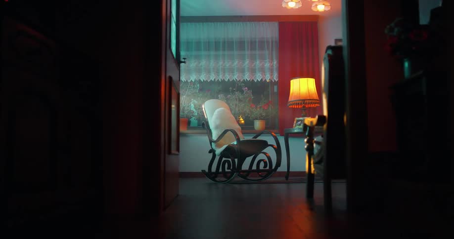 Armchair moving in a room next to a table lamp