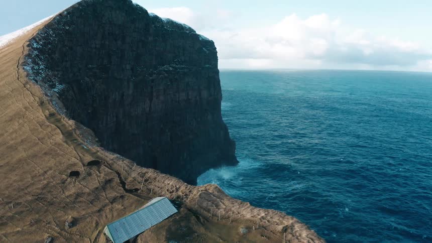 Aerial of a coastal mountain range with shelter at the top