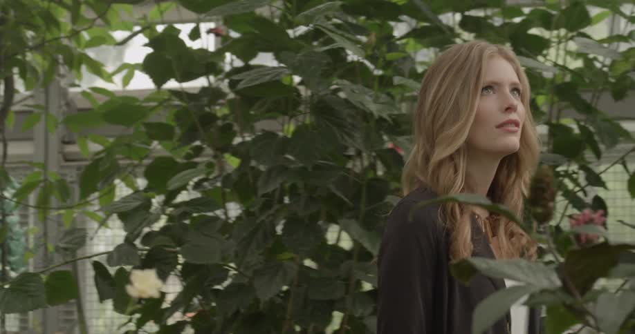 Woman walks through a greenhouse