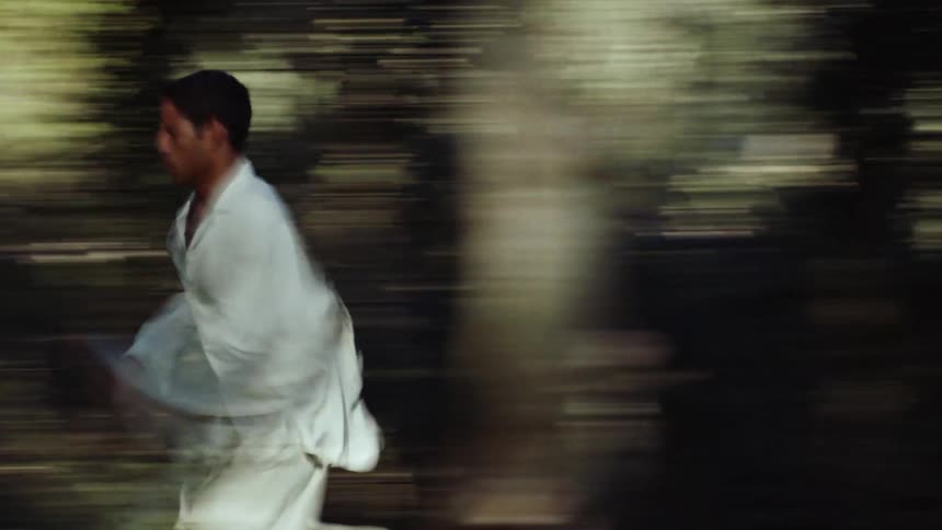 A boy runs through the park during the day
