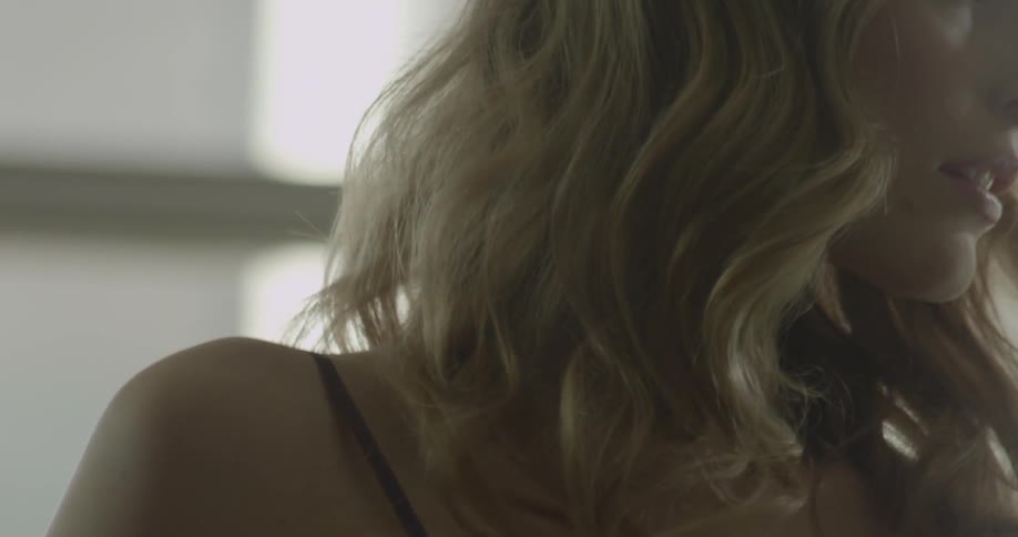 A woman looks at herself in a mirror adjusting her hair
