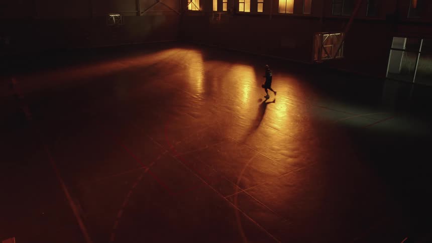 Black man playing basketball at night
