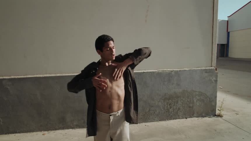 Black man in formal clothing dancing outdoors