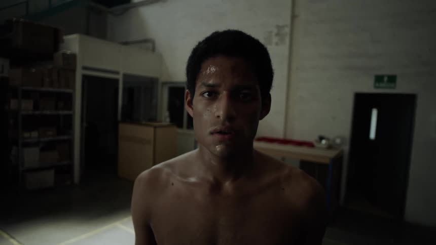 Portrait of a young shirtless man and sweaty body  inside a warehouse