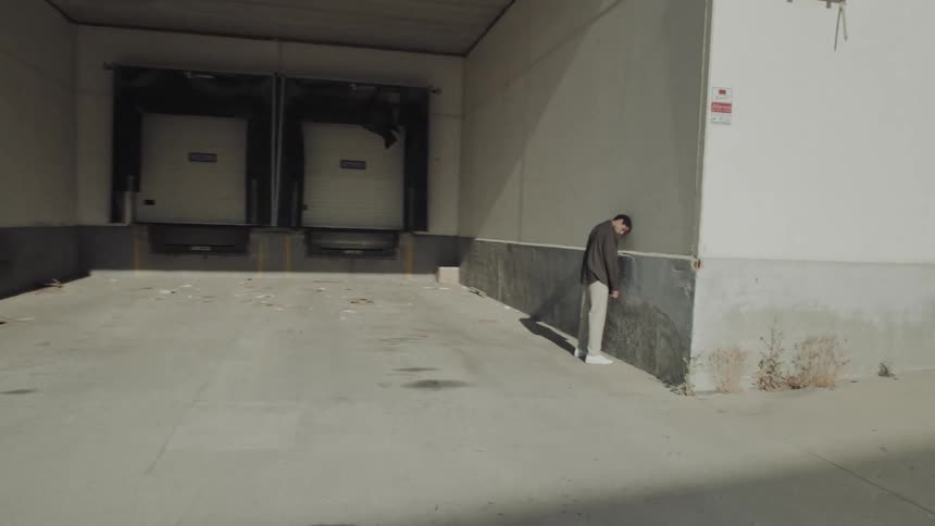 Man with his head against the wall dancing