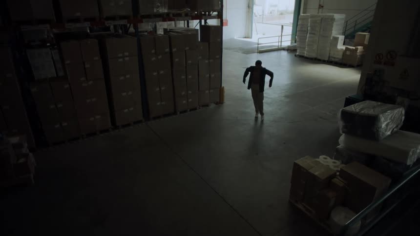 Man dancing and walking in a logistics center