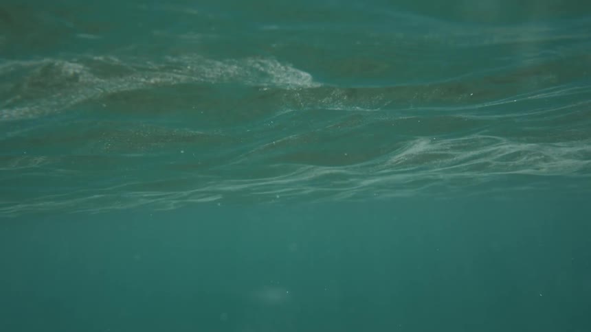 View from inside the turquoise blue sea with sunlight reflection