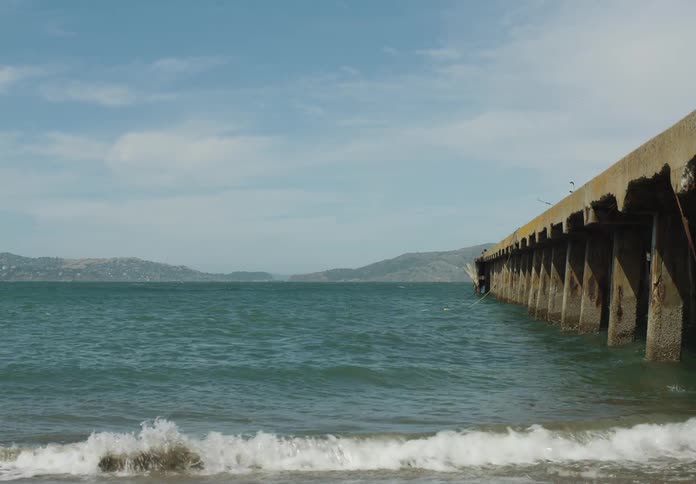A pier on the beach during a sunny summer day