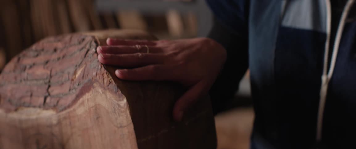 A woman traces her hand along pieces of wood
