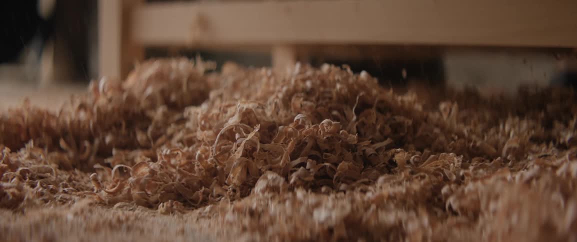 Closeup of shredded wood chips falling to the ground