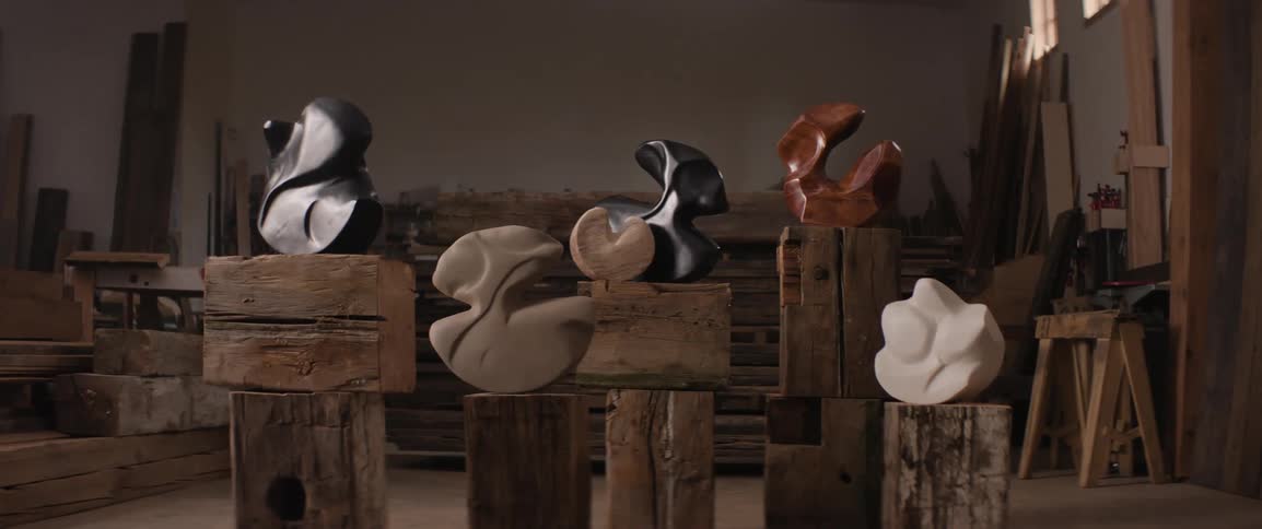 Various finished wooden sculptures are displayed in a wood shop