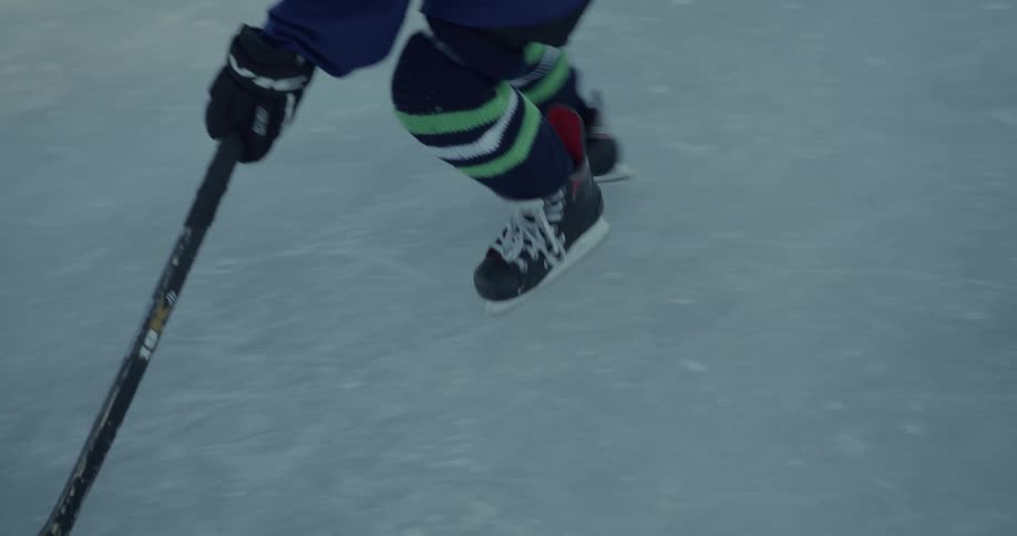 Hockey player moves puck across ice with stick
