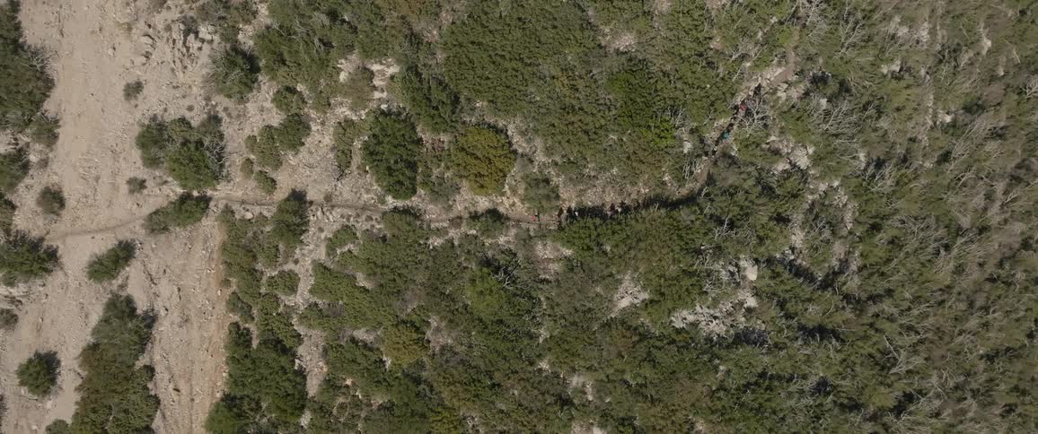 A group of hikers walking a path across grasslands