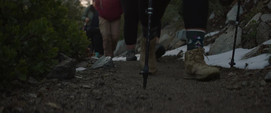 A group of hikers walking a path across grasslands