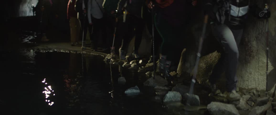 A clip of female hikers hiking a cave
